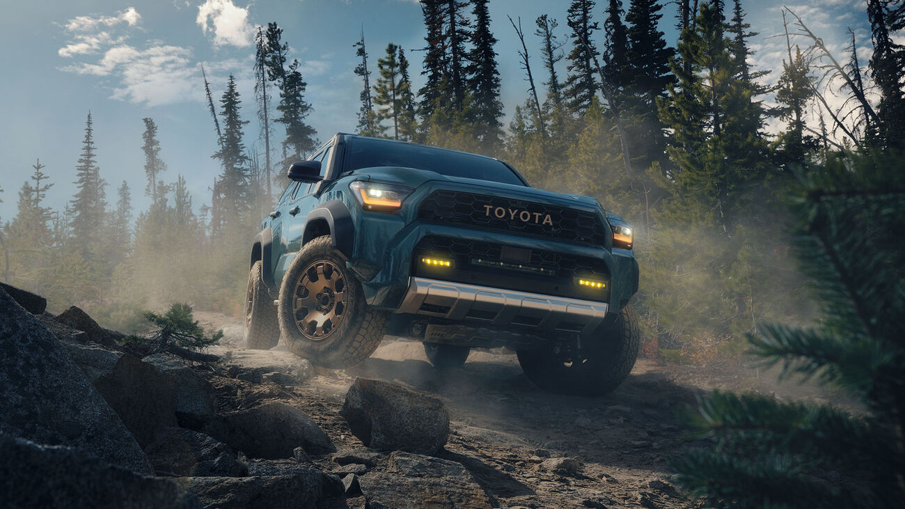 Toyota 4Runner i-FORCE MAX Trailhunter in Everest climbing over a small rocky peak.
