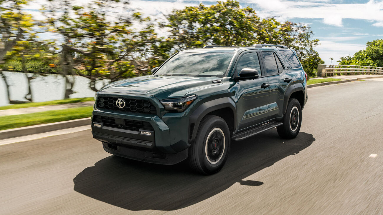 Toyota 4Runner i-FORCE MAX TRD Off-Road in Everest crusing down a local highway with lush green trees behind.