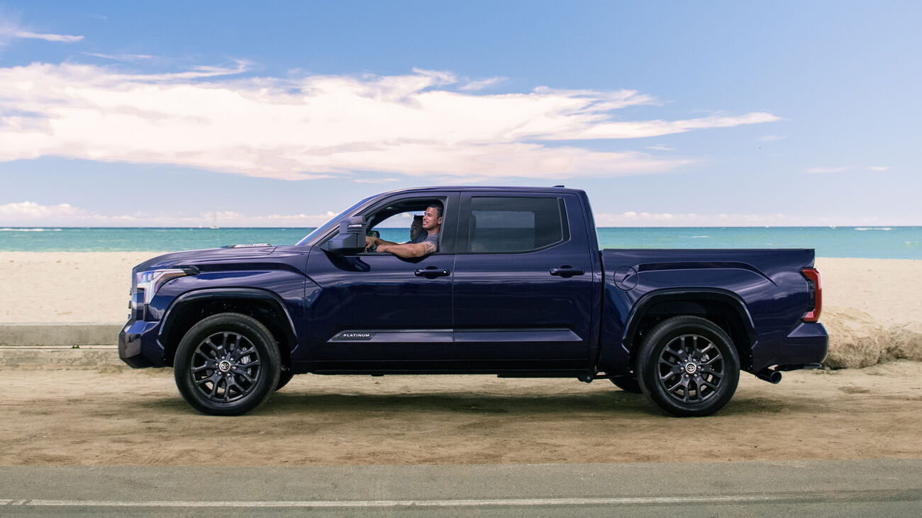 Toyota Tundra i-FORCE MAX Platinum in Blueprint parked along side the beach with its passengers looking into the distance