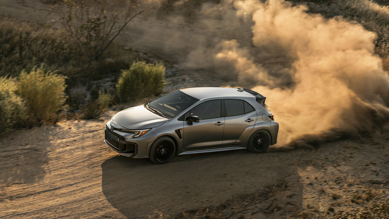 GR Corolla Premium Plus in Heavy Metal exiting a corner on a dirt road with a cloud of dust following
