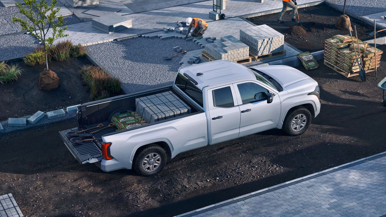 Toyota Tundra SR5 in Ice Cap on a job site hauling bricks and concrete in the bed. 