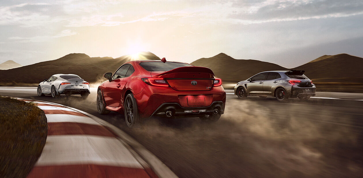 The Toyota GR Supra, Toyota GR Corolla, and Toyota GR86 racing through a corner on the race track.