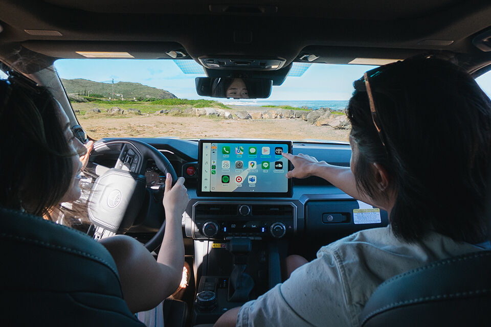 Toyota 4Runner i-FORCE MAX TRD Off-Road in Everest with the passenger interacting with the 14-in multimedia touchscreen.