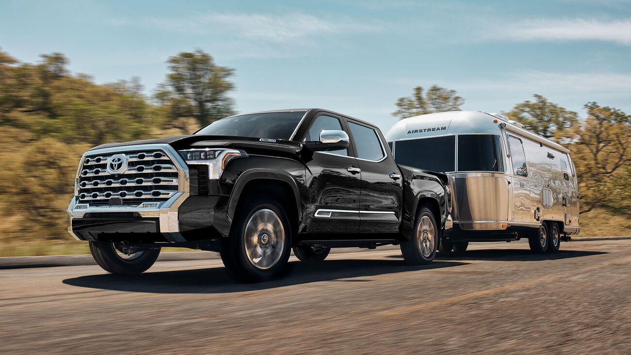 Toyota Tundra i-FORCE MAX 1794 Edition in Midnight Black Metallic towing an airstream mobile home down the highway.